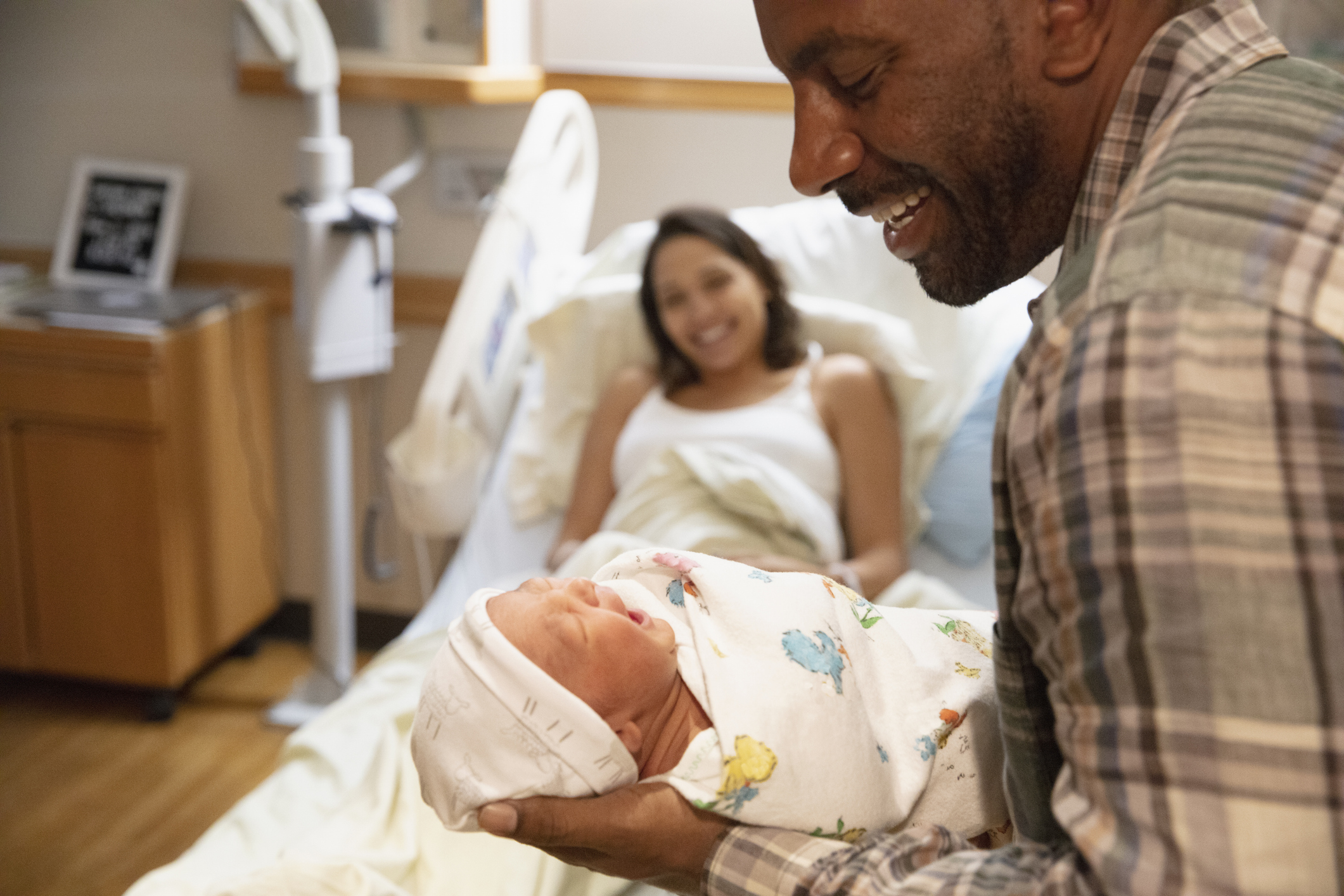 Father holding newborn baby at hospital