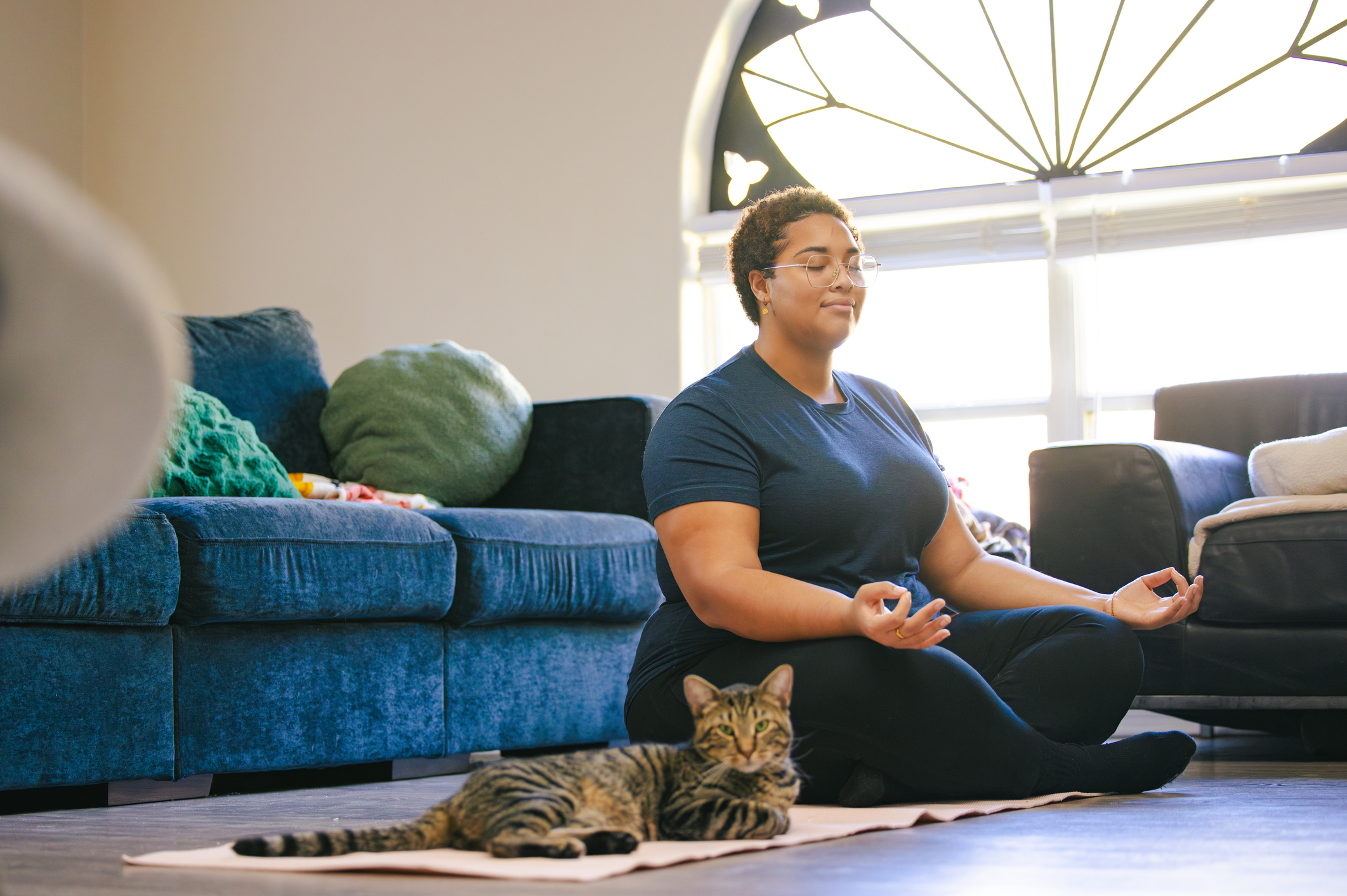 Black Plus Size woman doing Yoga at home with Pets