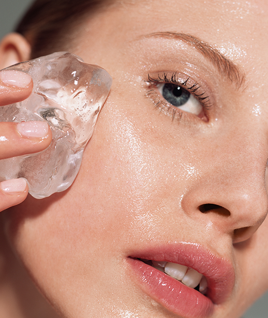 Woman putting ice on her face