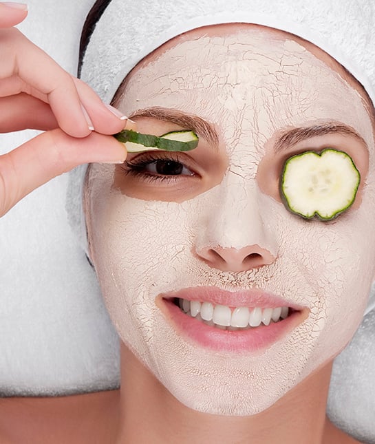 Cucumber slices on a woman's eyes