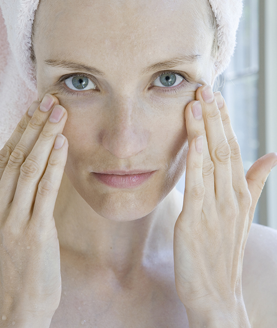 WOMAN LOOKING AT CAMERA TOUCHING FACE