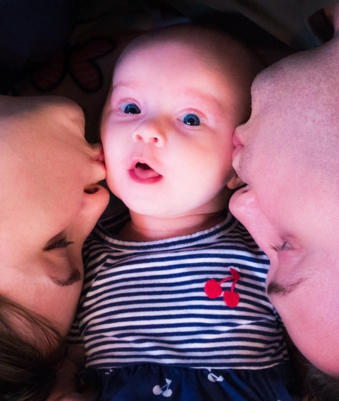 162989-baby-surprised-parents-kiss.jpg