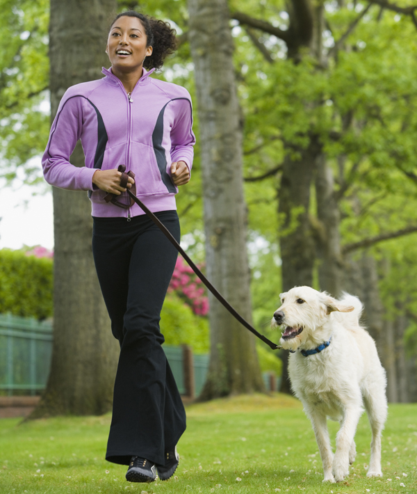African American woman jogging with dog