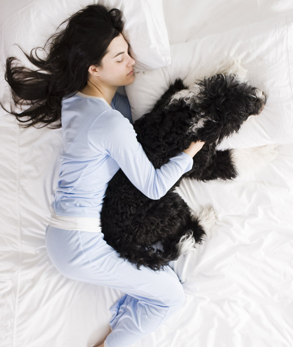 woman and her dog in bed