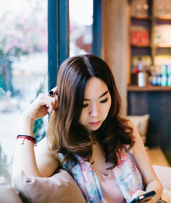 169459-woman-in-restaurant-looking-down-at-phone.jpg