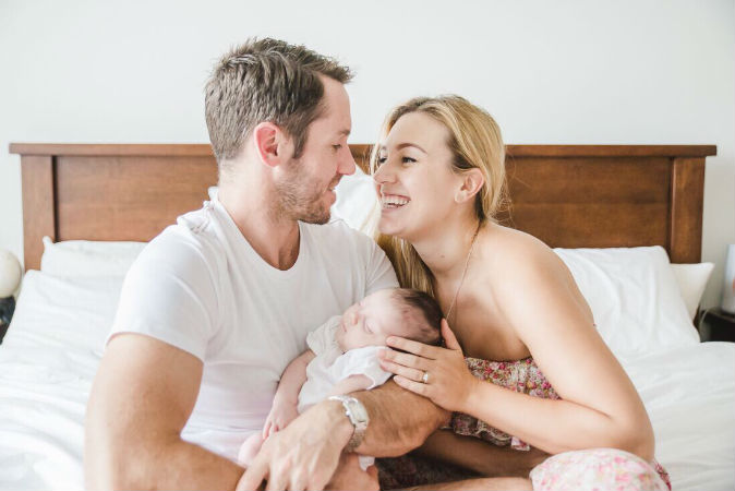 couple-bed-holding-baby