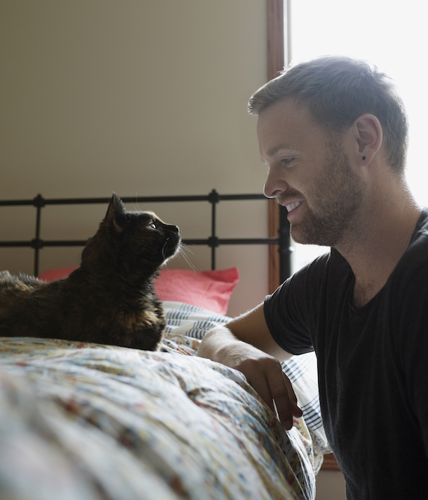Man and cat face to face in bedroom