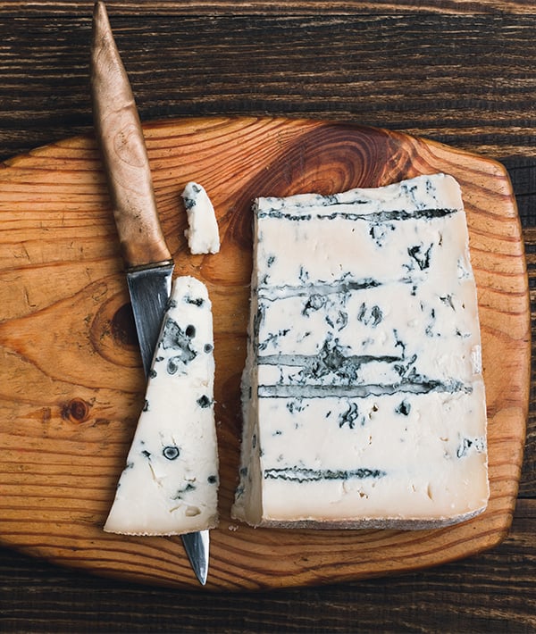 Gorgonzola cheese on wooden cutting board
