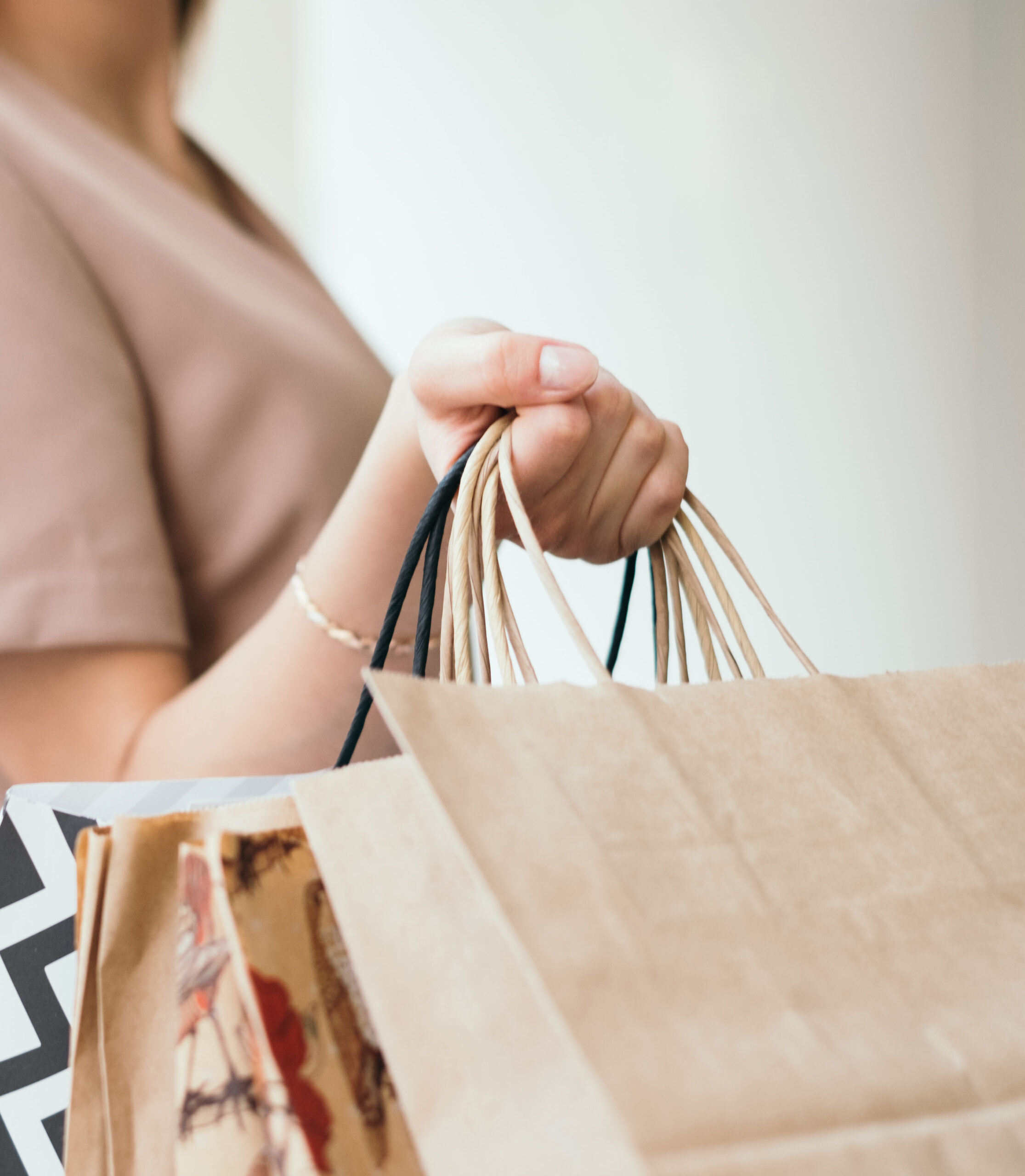 230506-woman-hand-holding-shopping-bags_t20_xza1mr.jpg