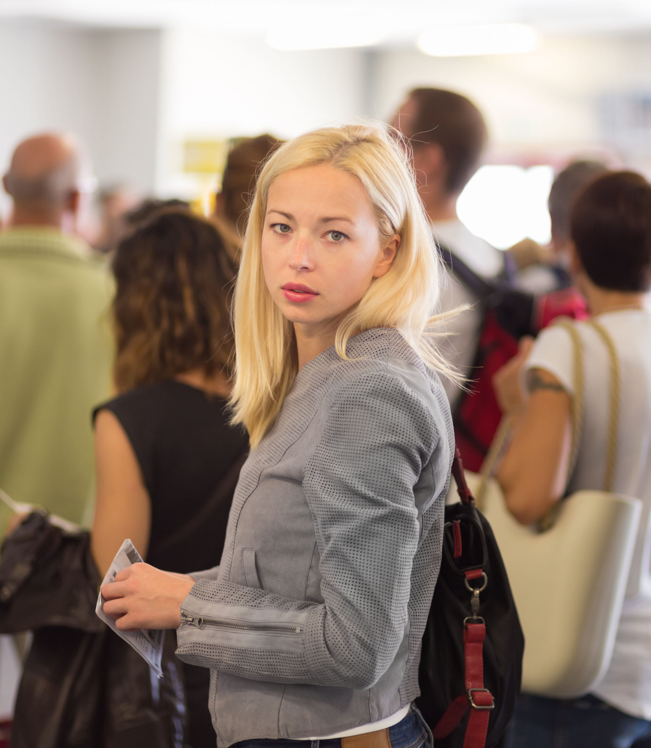 Young blond caucsian woman waiting in line.