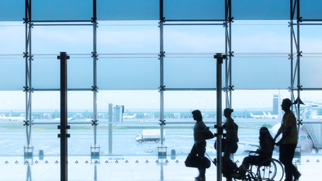 Passengers in the interior of airport - Passengers and disabled person in the interior of airport