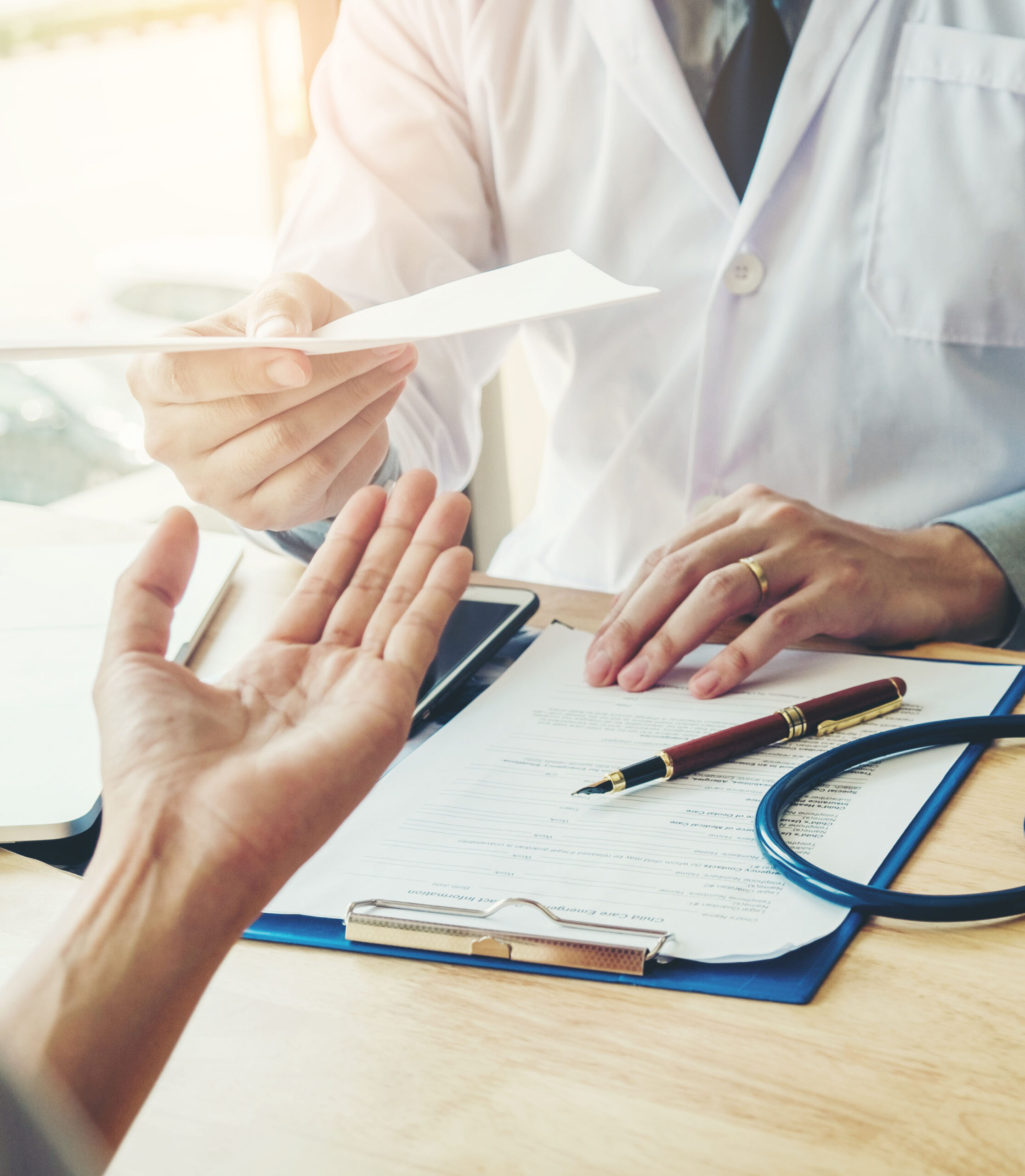 Doctor or physician writing diagnosis and giving a medical prescription to female Patient