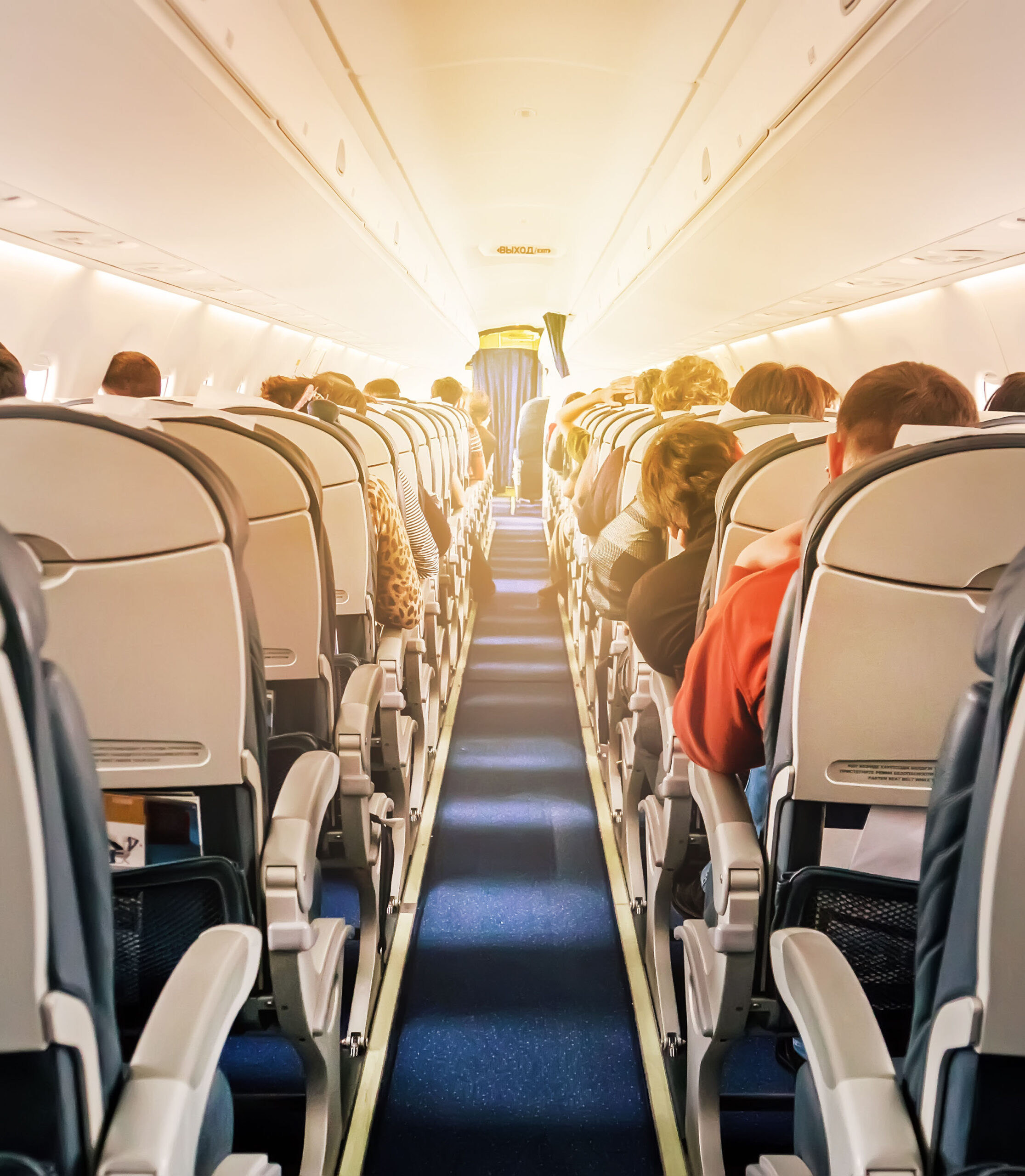 Commercial aircraft cabin with rows of seats down the aisle