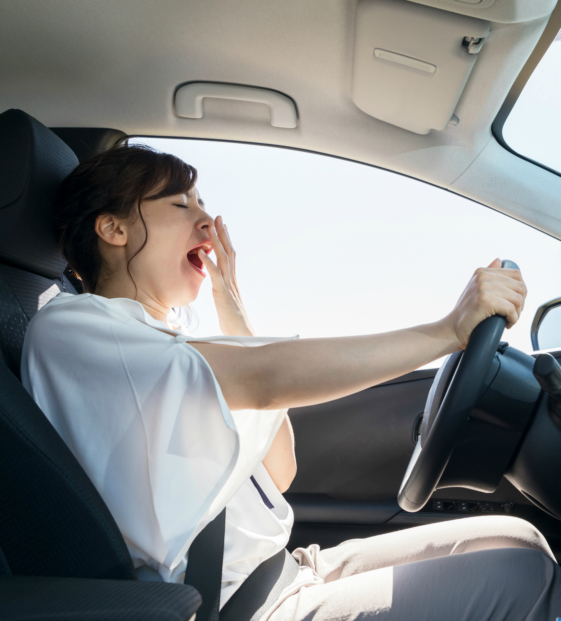 yawning female driver. falling asleep at the wheel concept.