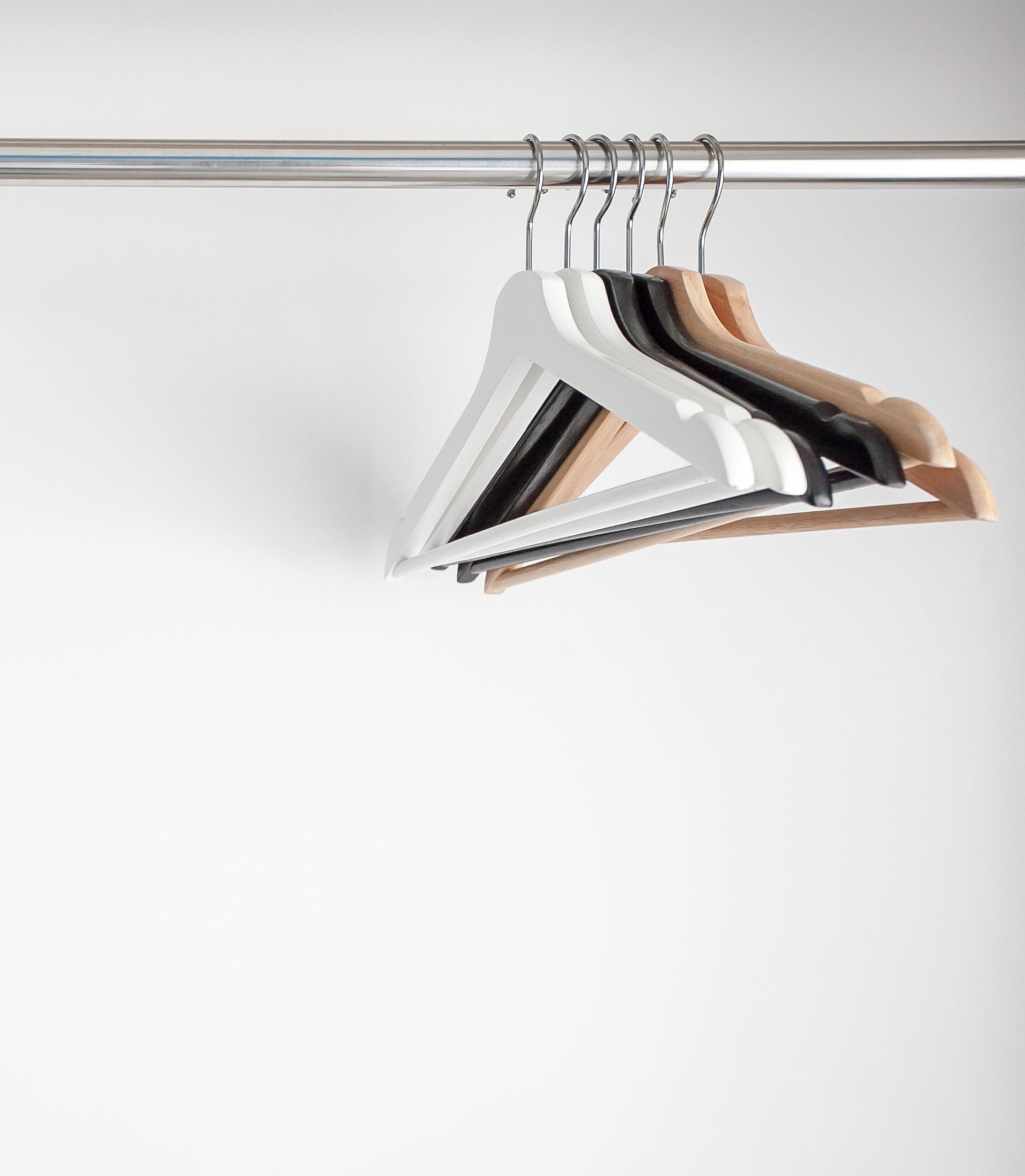 Wooden hangers on white wall background