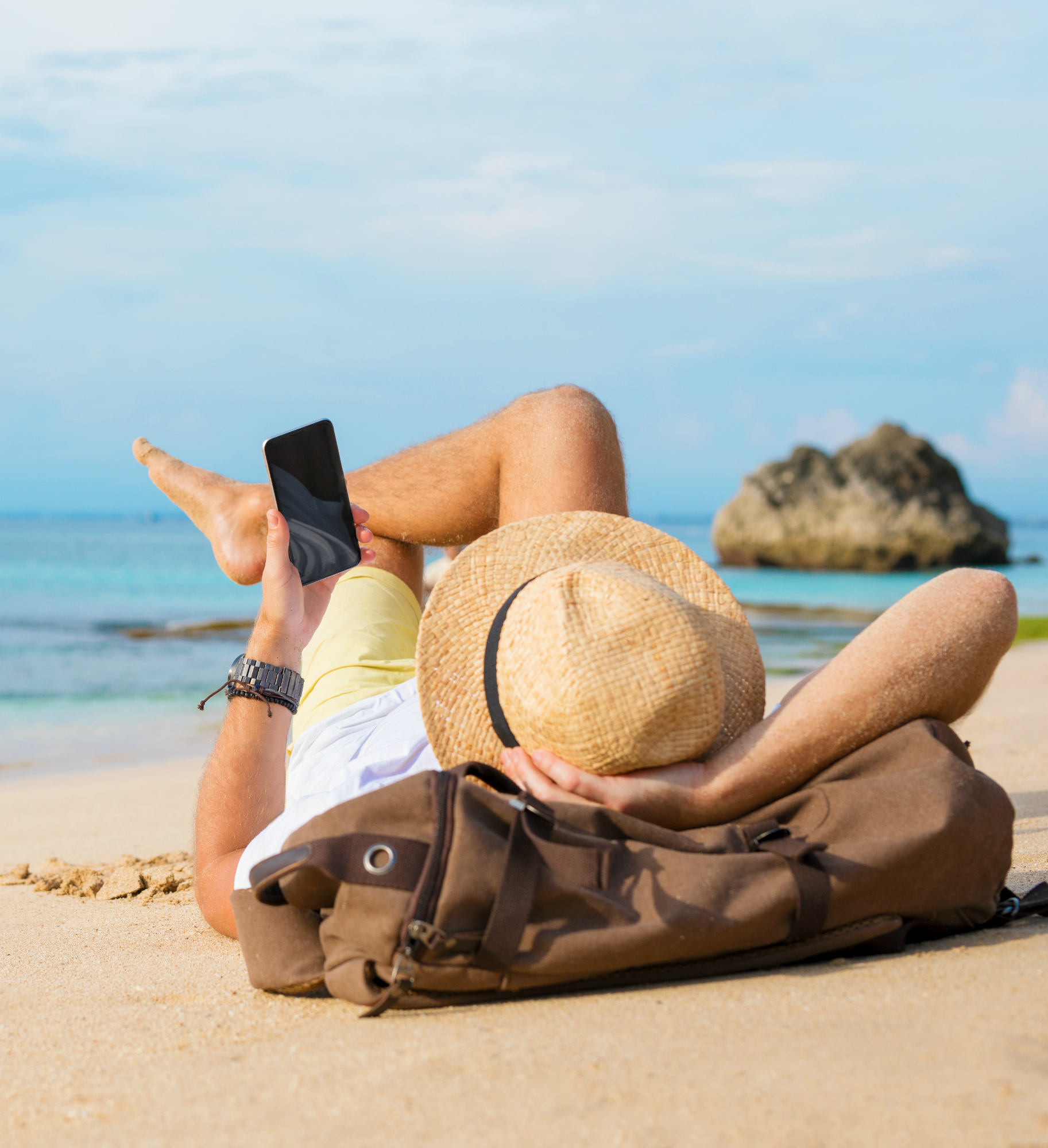 Guy with smartphone lying on the beach
