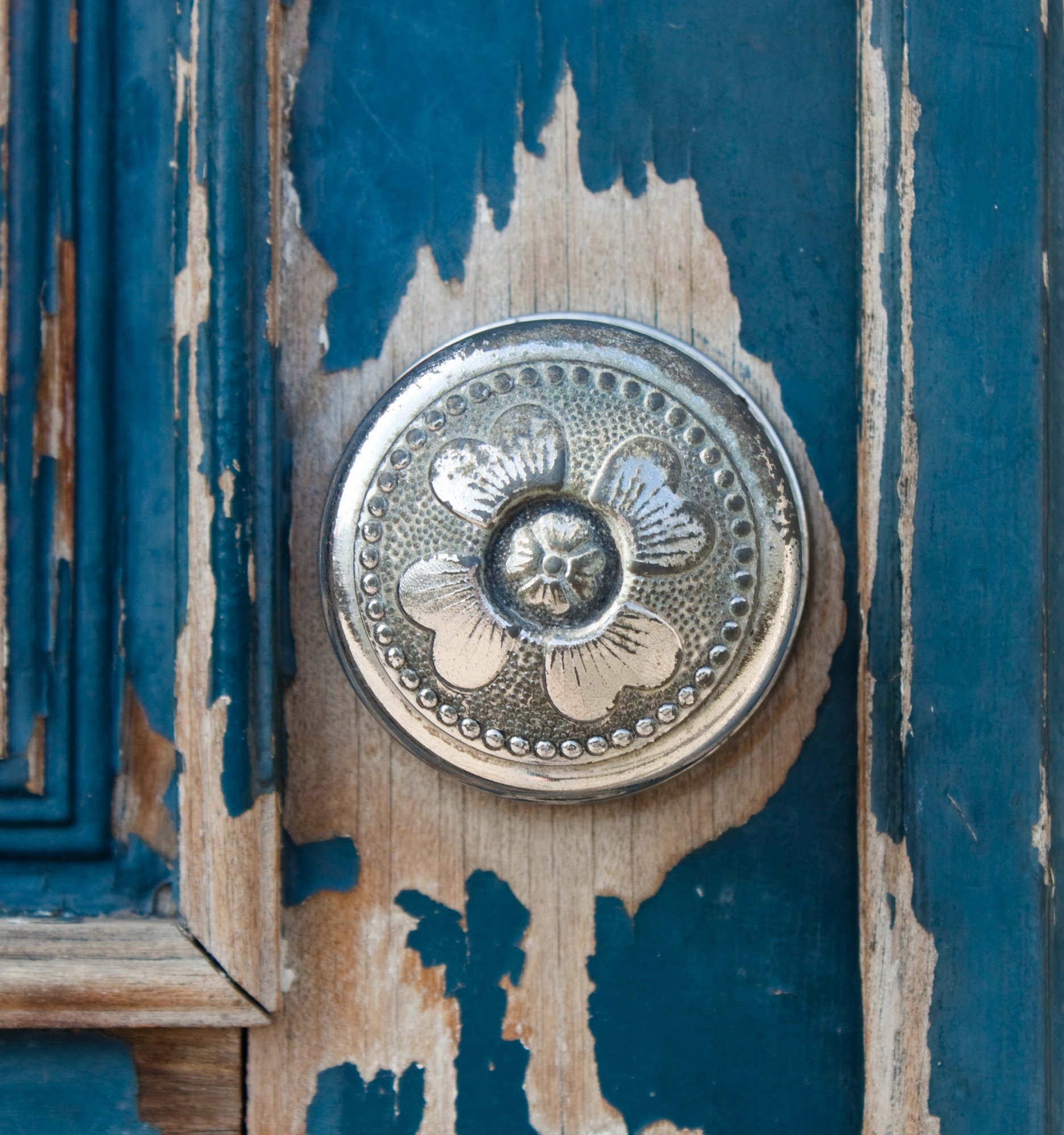 Silver metal door knob on an old wooden door