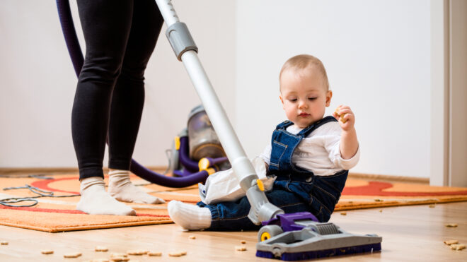 Cleaning home - mother and child - Woman cleaning with vacuum cleaner