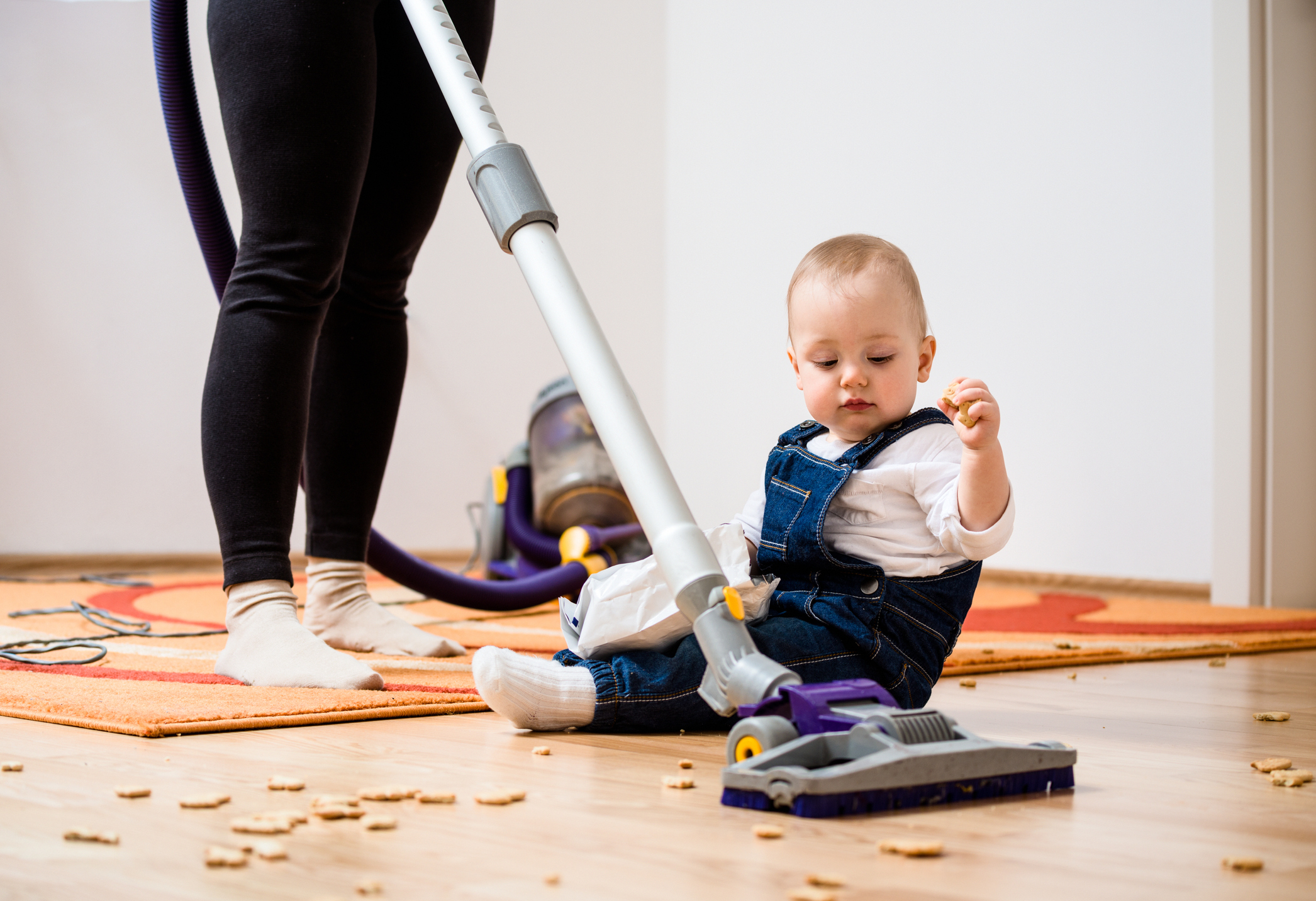 Cleaning home - mother and child - Woman cleaning with vacuum cleaner