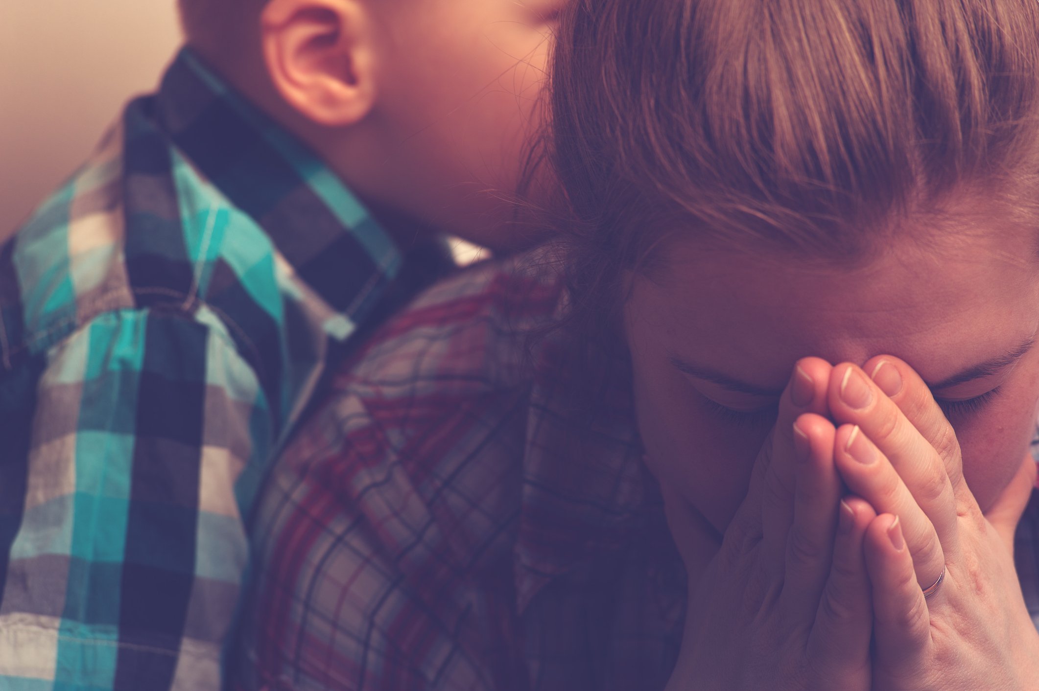 Crying unhappy mother with child at home - Crying unhappy woman covering her face with hands while little child standing next to her. Tired and depressed mother with kid at home. Family relations problems.