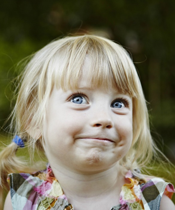 Young girl in backyard smiling looking up