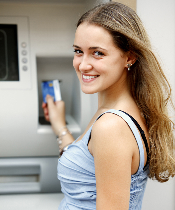 Young woman withdrawing money from credit card with ATM