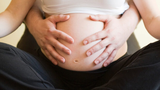 man holding pregnant wife's belly