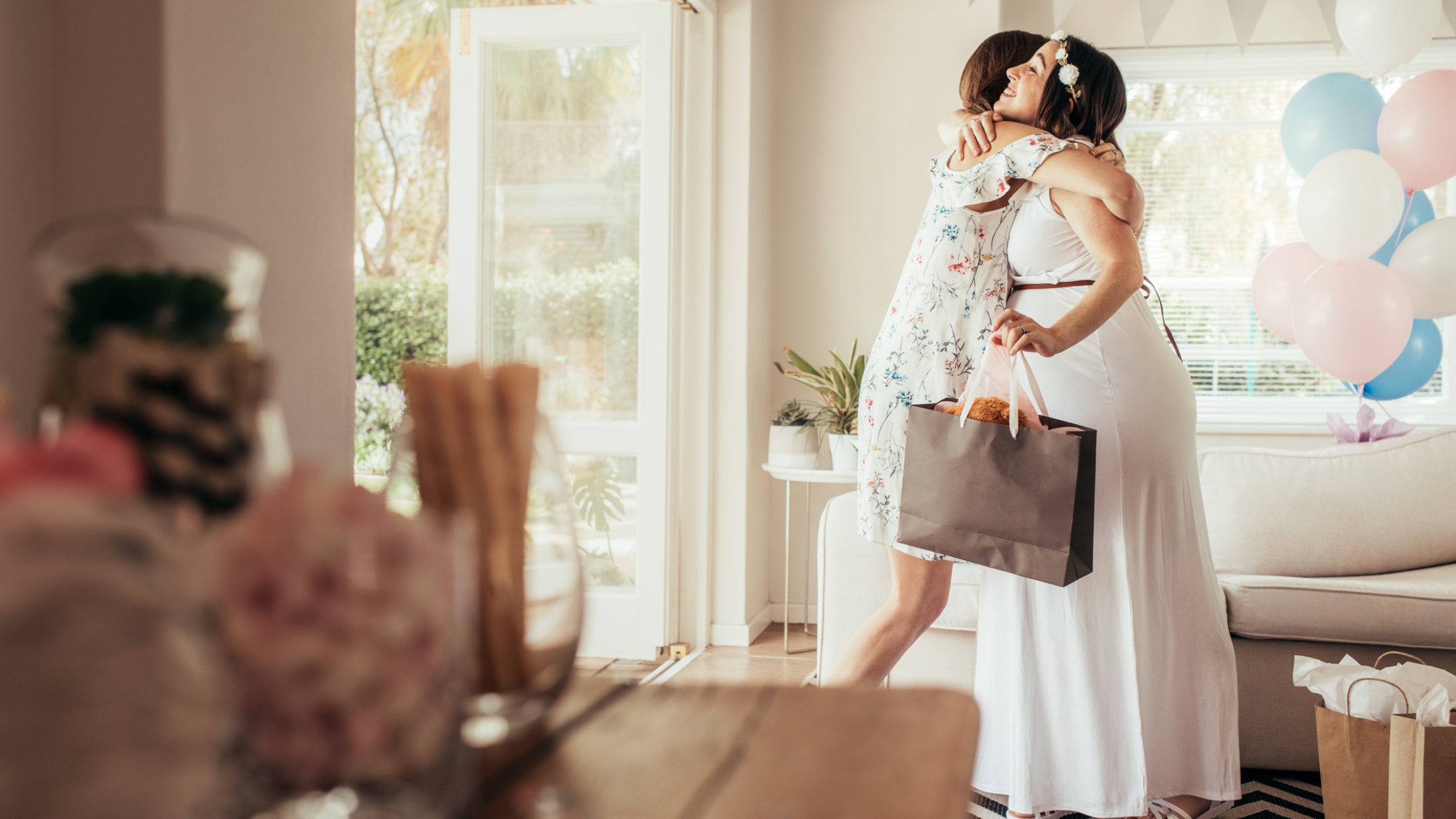 Pregnant mom hugs guest at baby shower