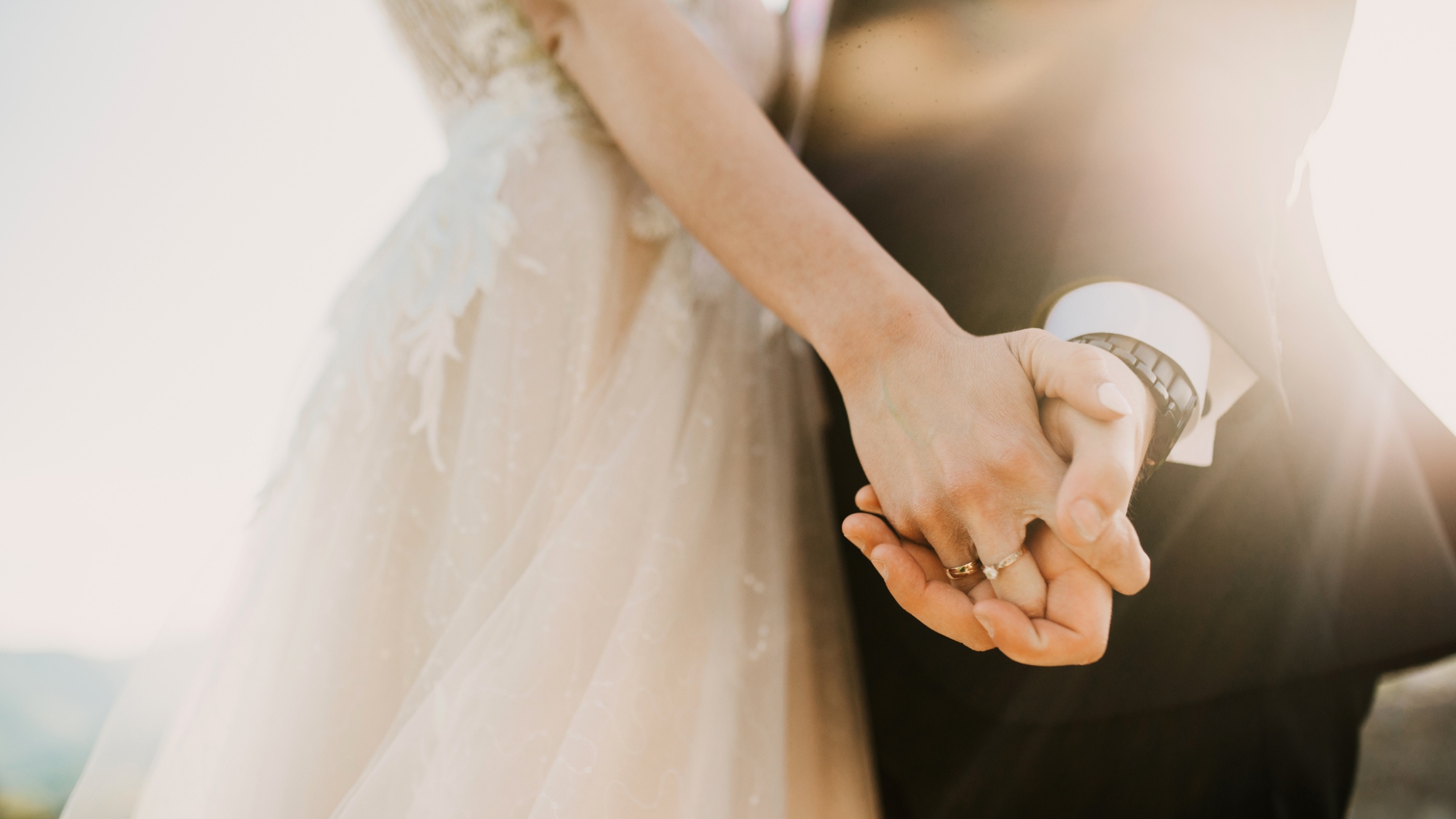 Bride and groom hold hands at wedding