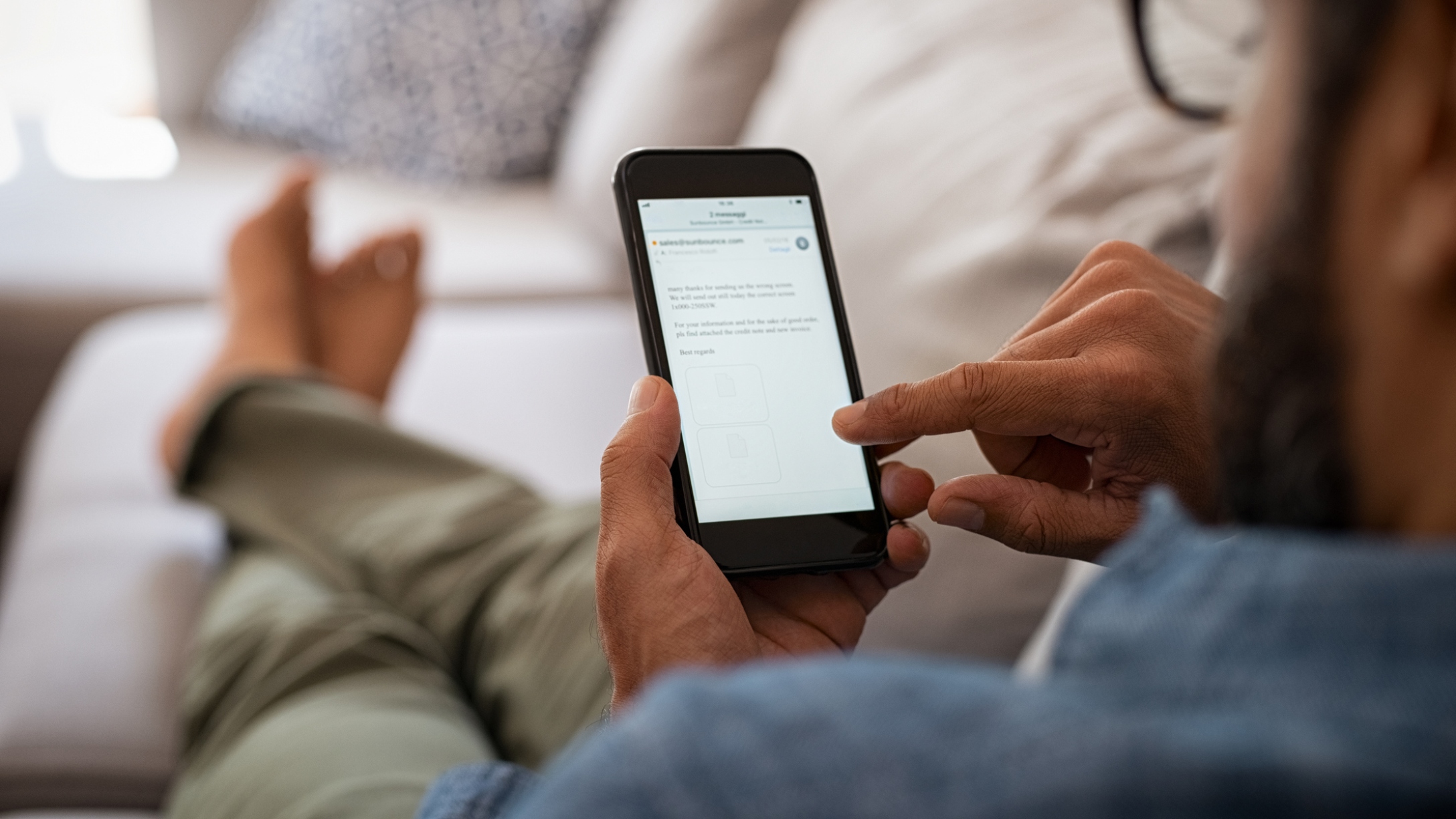 Man sits on couch on his phone