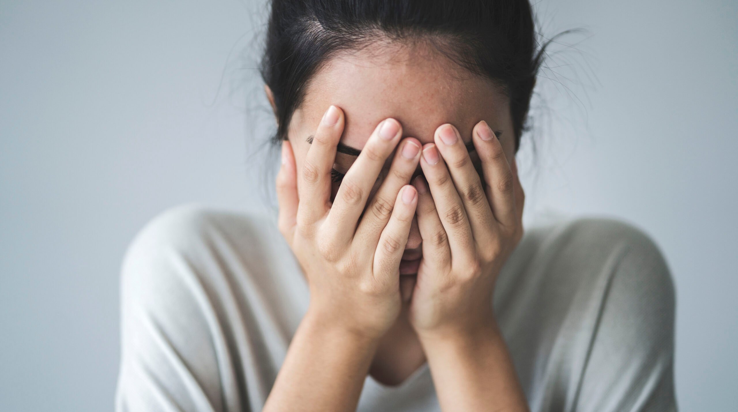 Young girl covering her face with her hands