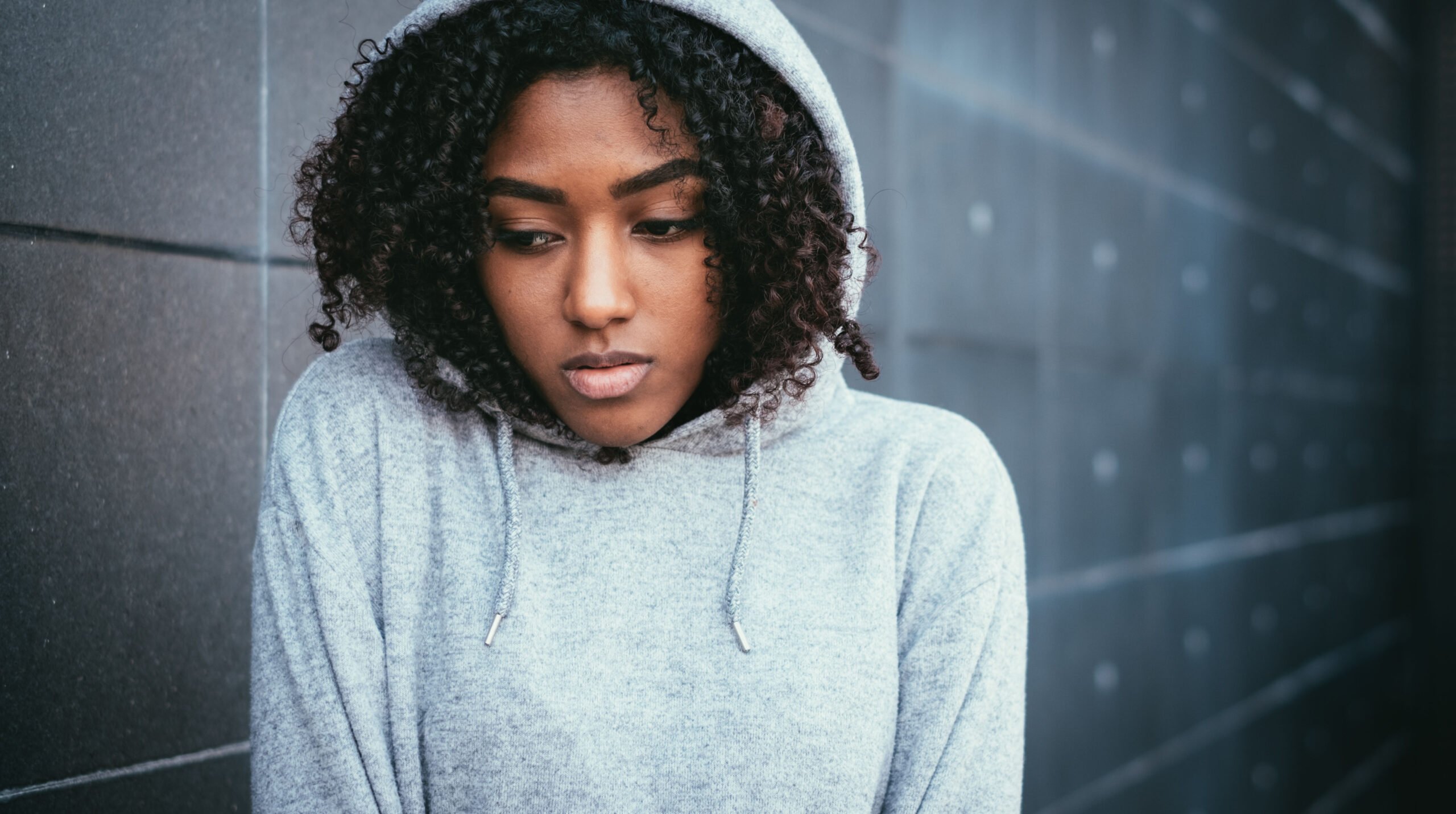 Sad and lonely teenager portrait in the city street