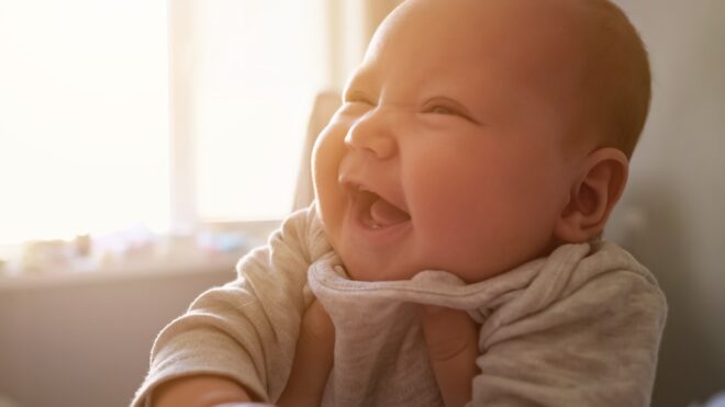 Baby being held up gives a big smile