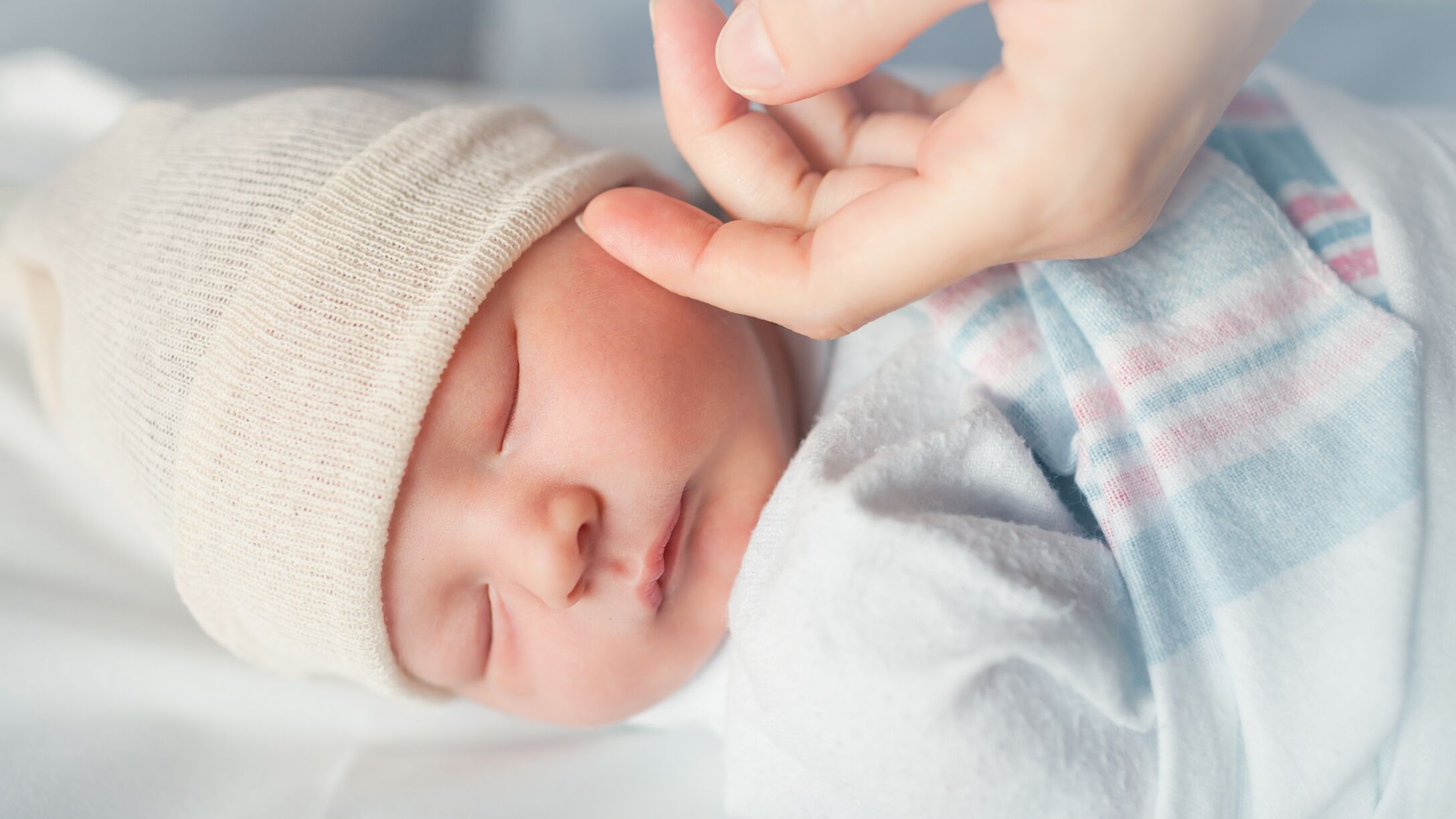 Newborn baby sleeping with hospital blanket swaddle