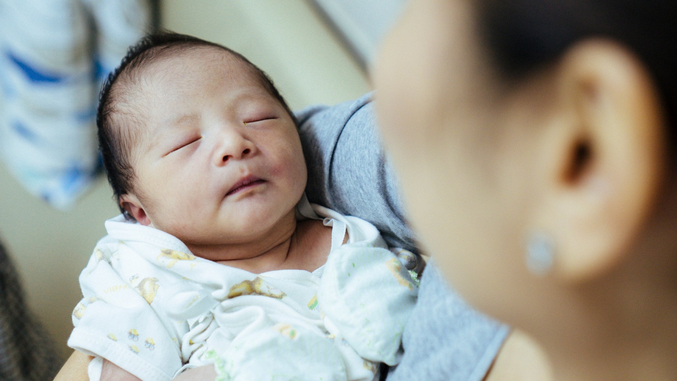 Grandmother holds newborn Asian baby