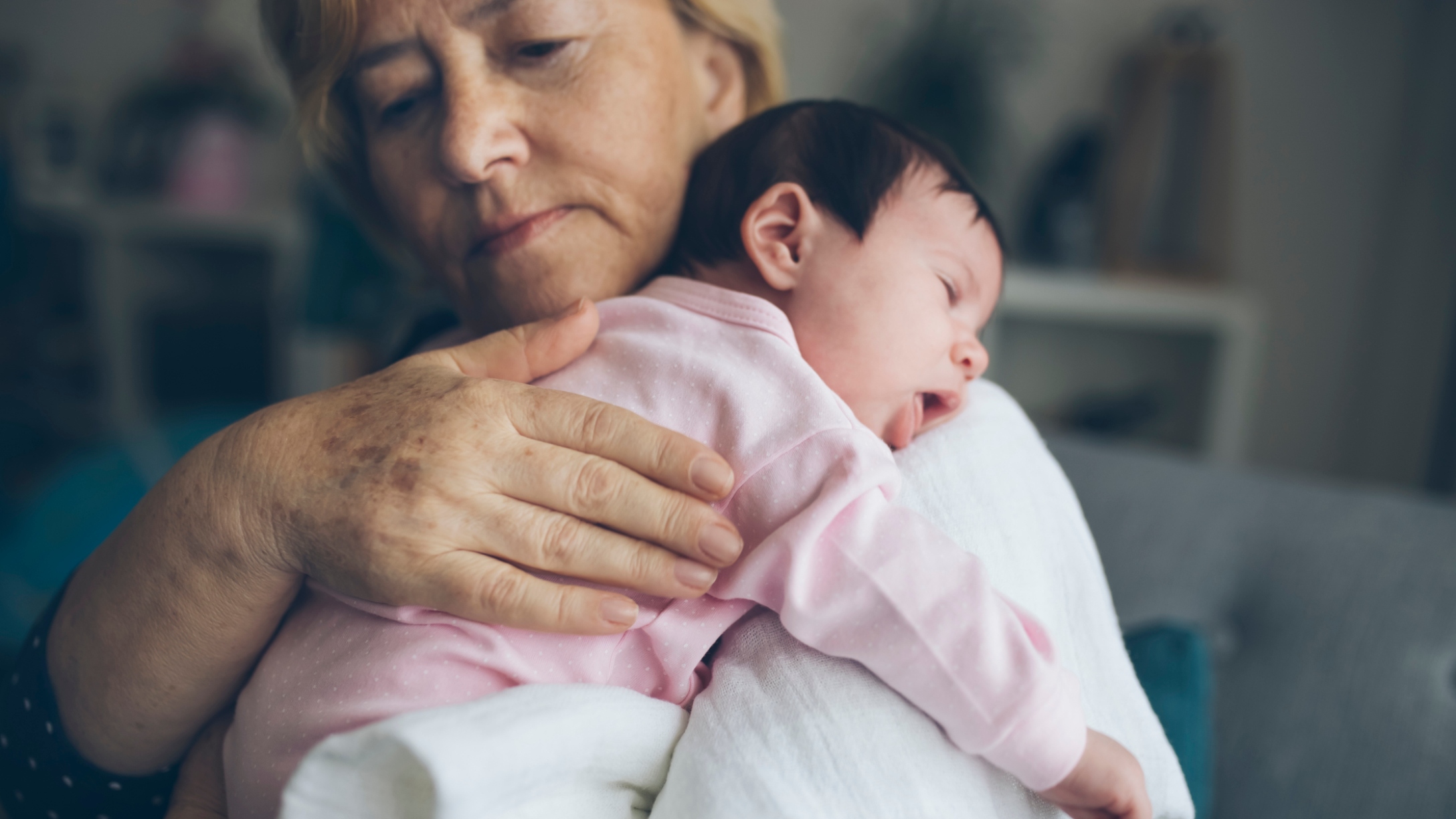 Grandmother holds baby girl and burps her