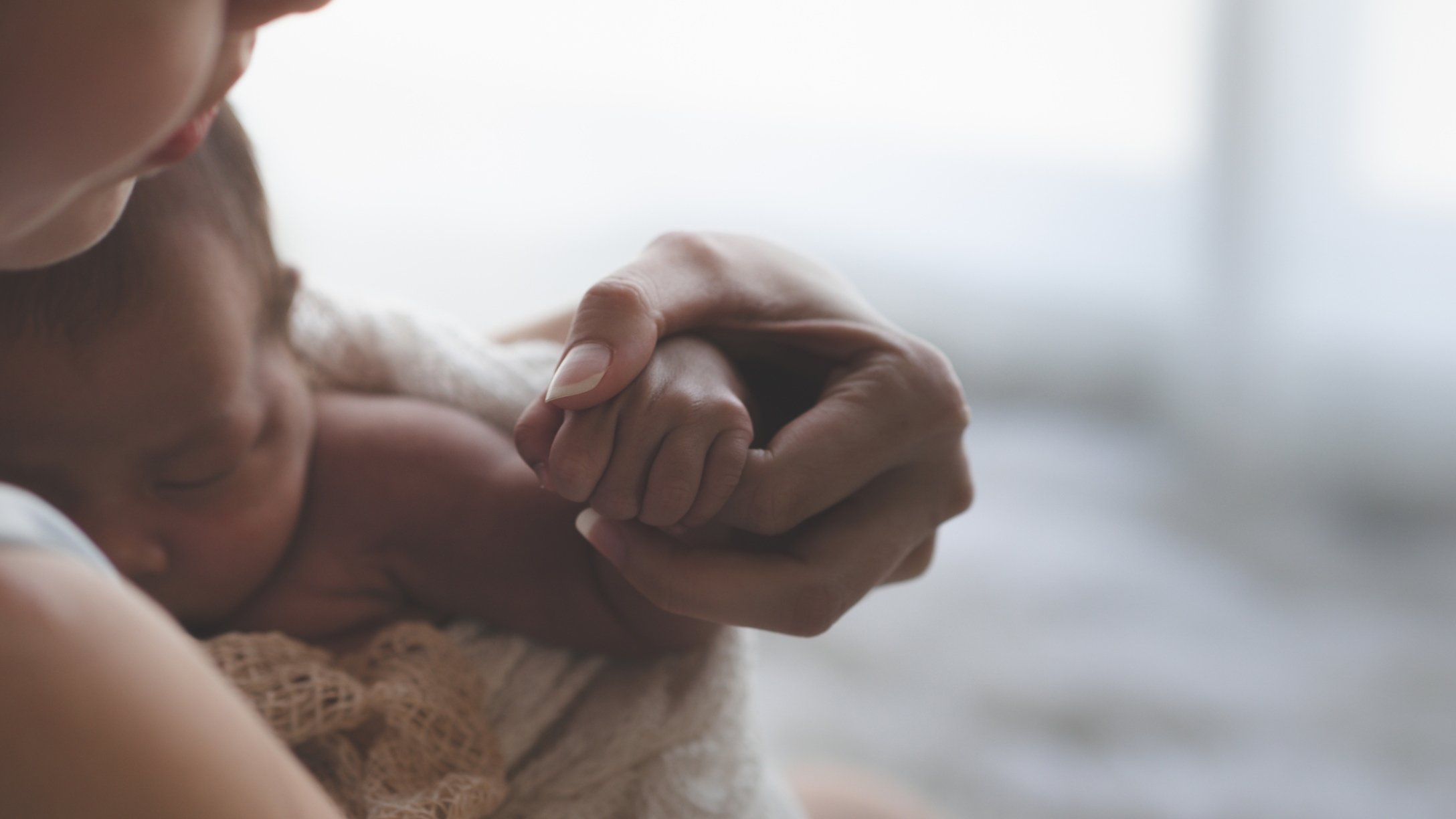 Mom holds newborn baby close
