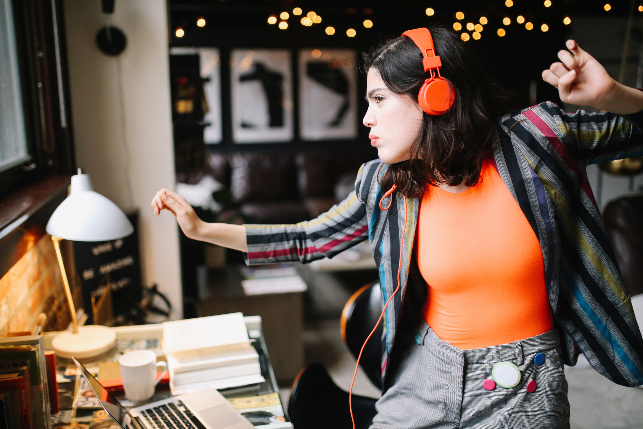 young millennial dancing to the music in her Downtown Los Angeles apartment