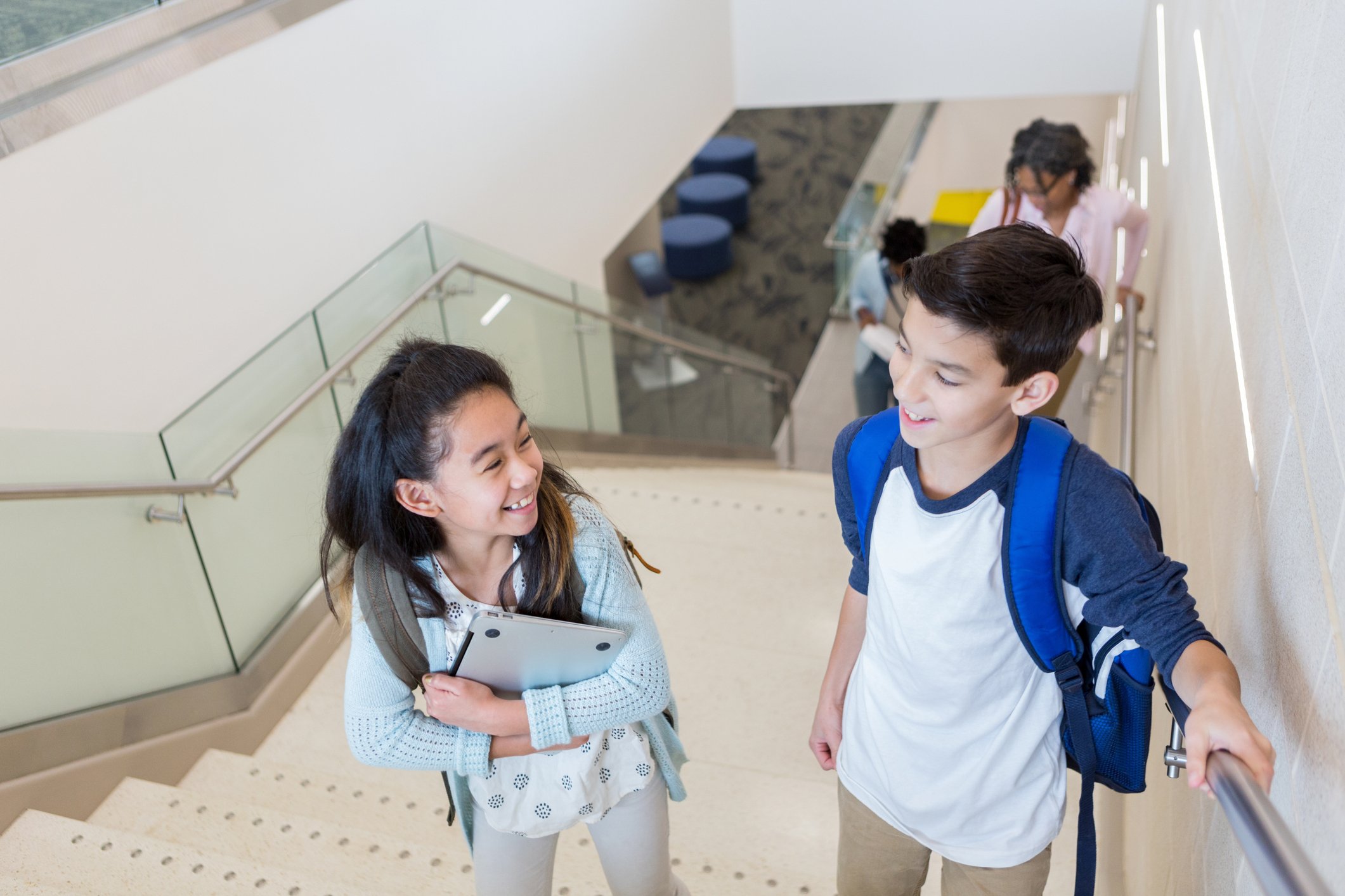 Elementary students climb stairs in school