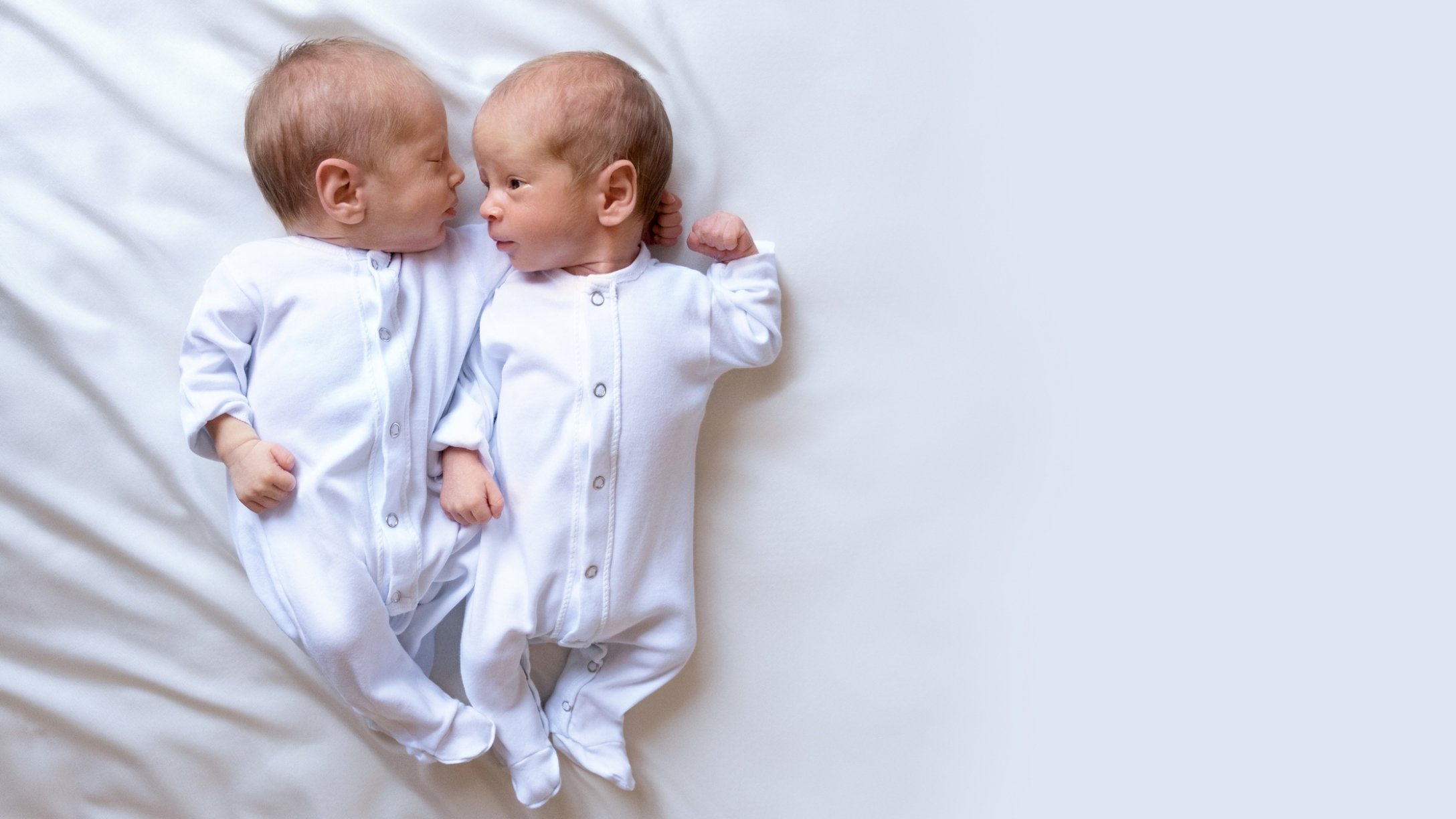 Two twin boys lay side by side