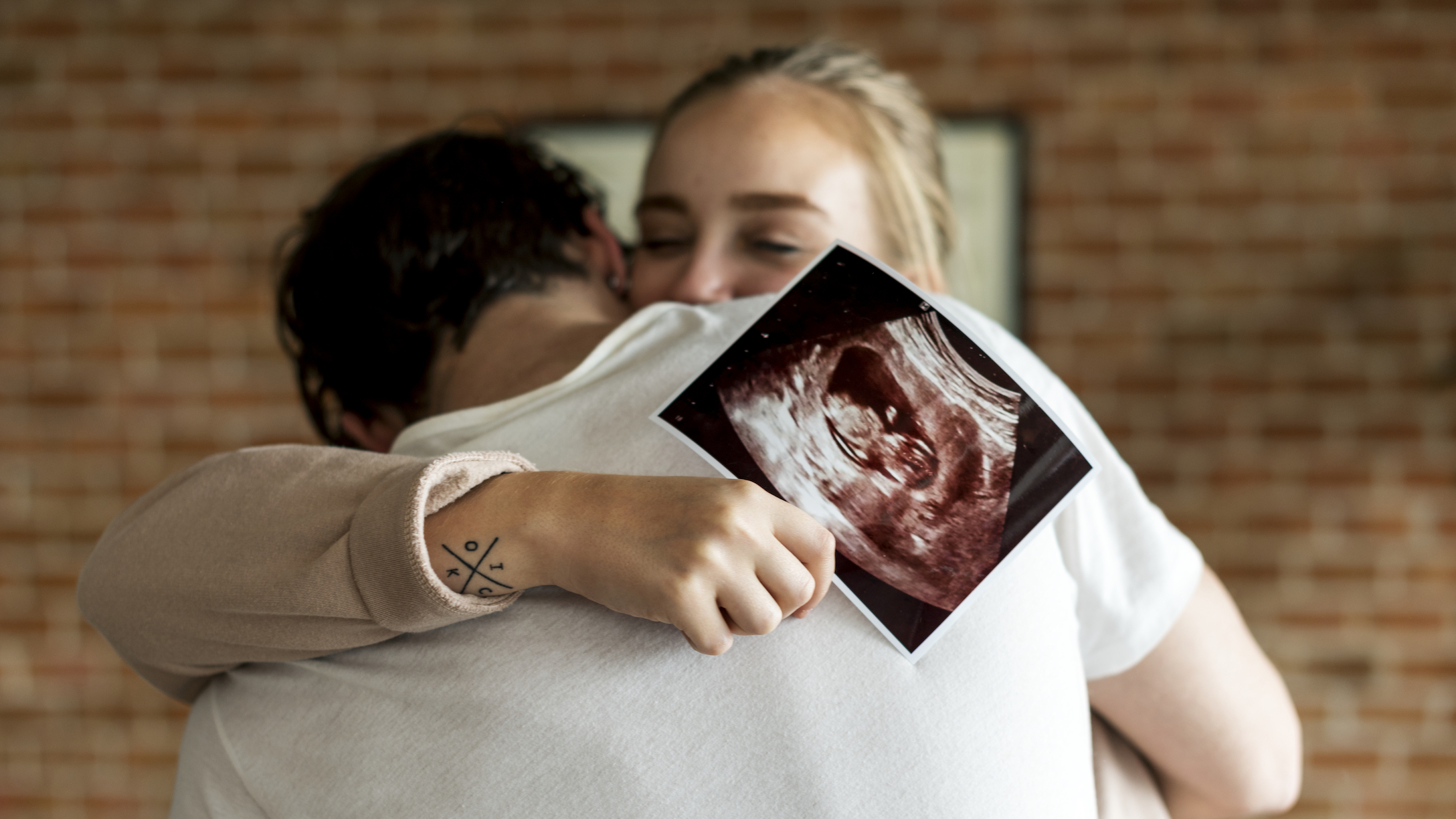 Couple hugging with baby sonogram