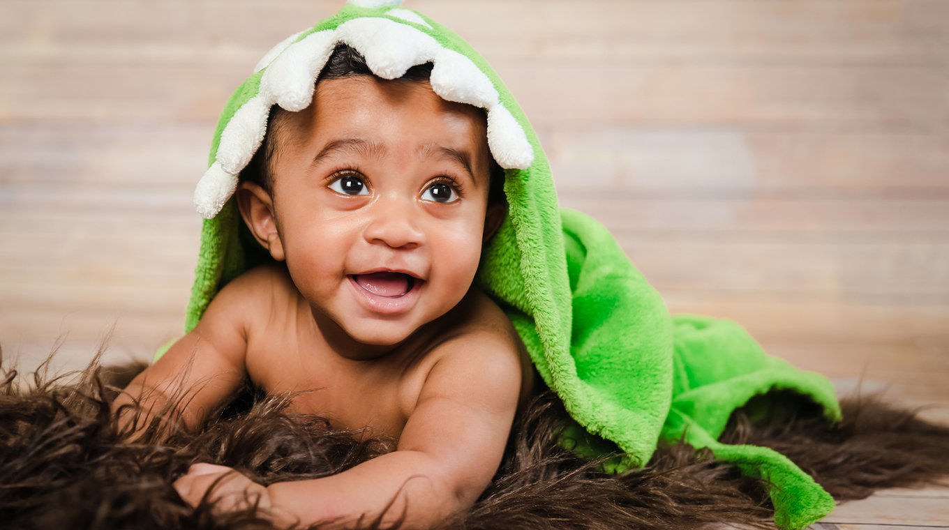 Infant dogla boy wearing bath robe laying on tummy belly