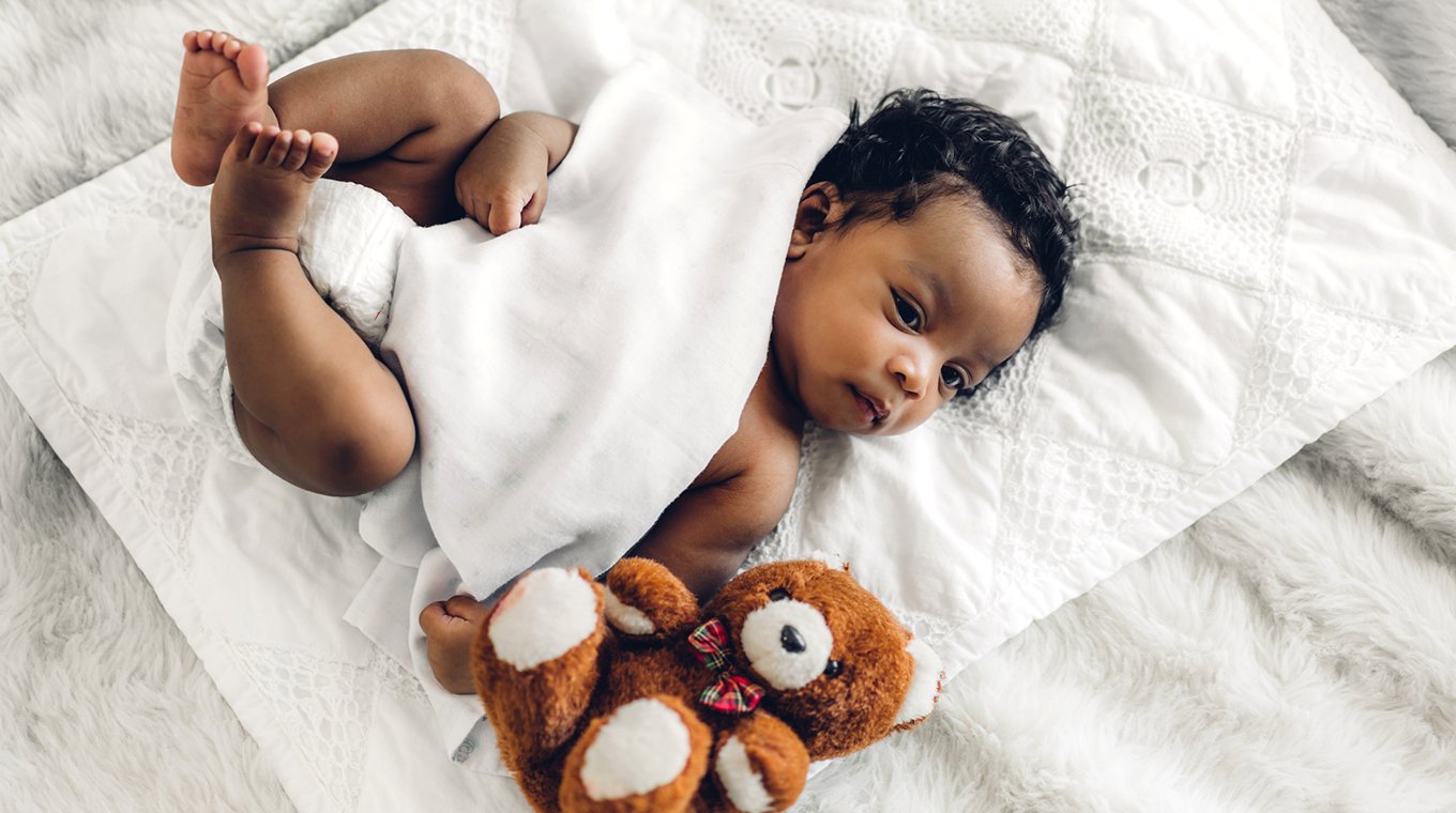 Portrait of cute adorable little african american baby sleep in a white bedroom