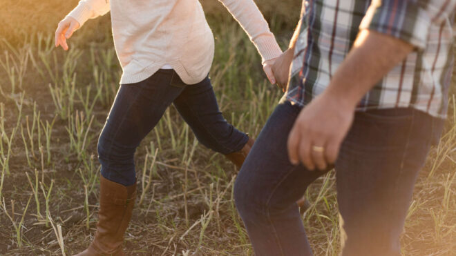 couple-holding-hands-field