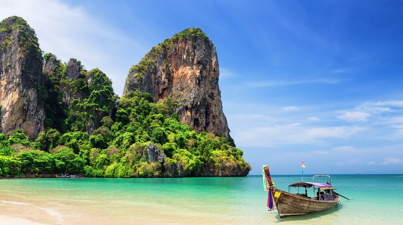 Thai traditional wooden longtail boat and beautiful sand beach