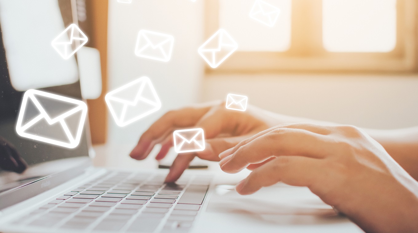 Email marketing and newsletter concept. Hand of man sending message and laptop with e-mail icon