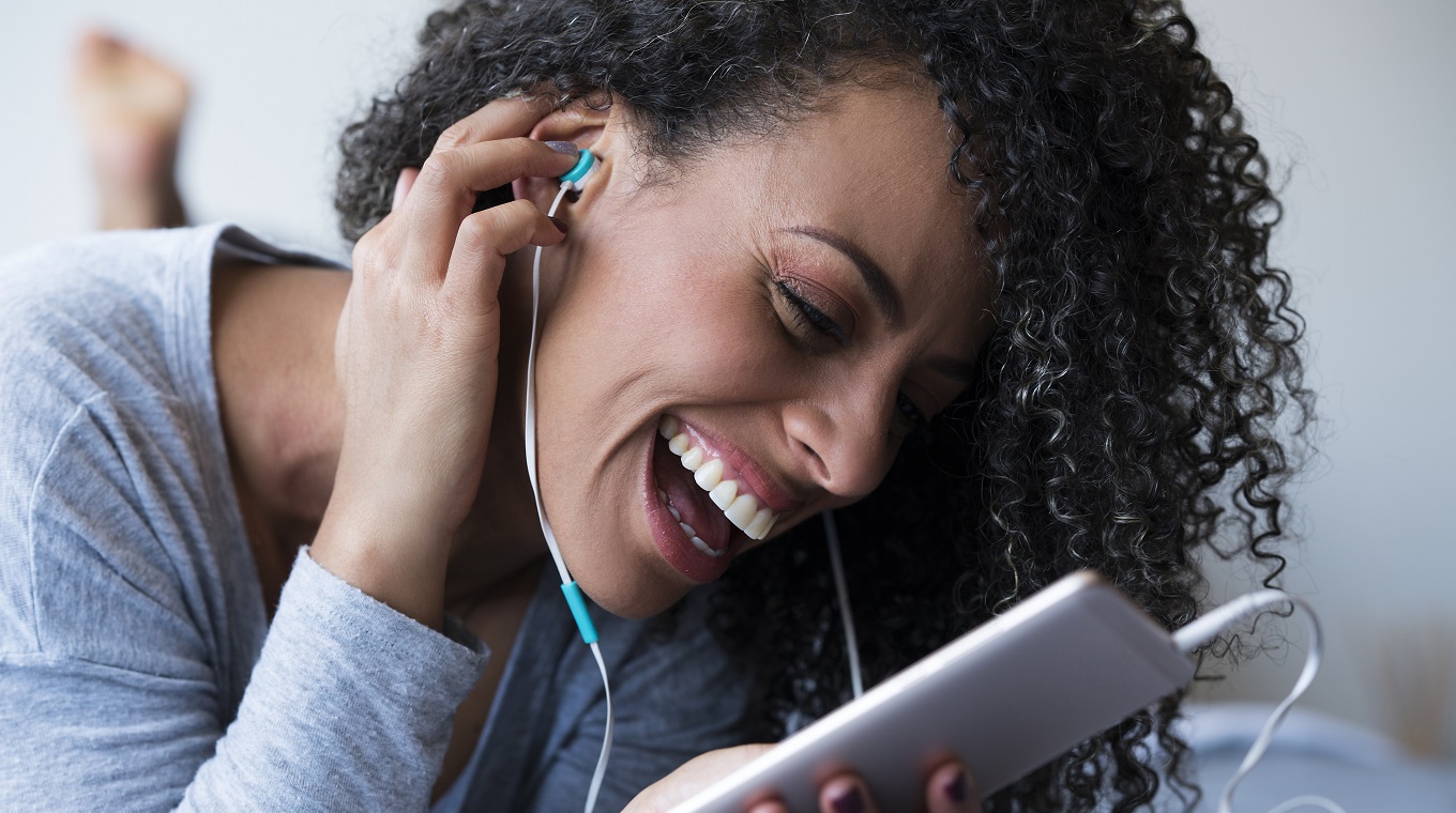 Happy woman enjoying while listening to a podcast