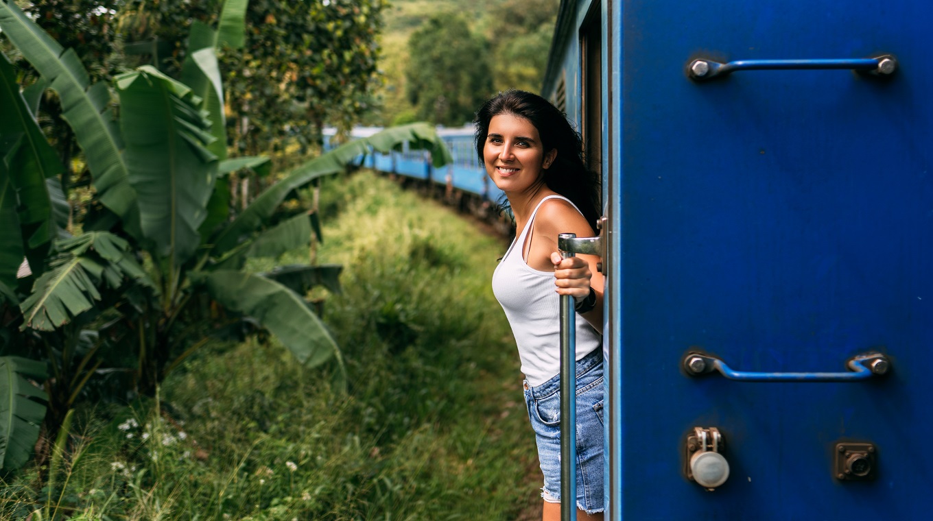 Beautiful girl traveling by train among mountains. The girl travels by train to beautiful places. Travel by train. Travelling to Asia. Trains Sri Lanka. Railway transport. Railway. Transport Asia