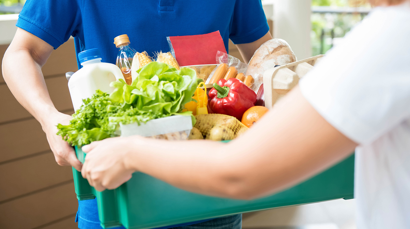 Agrocery delivery man delievering food to a woman at home
