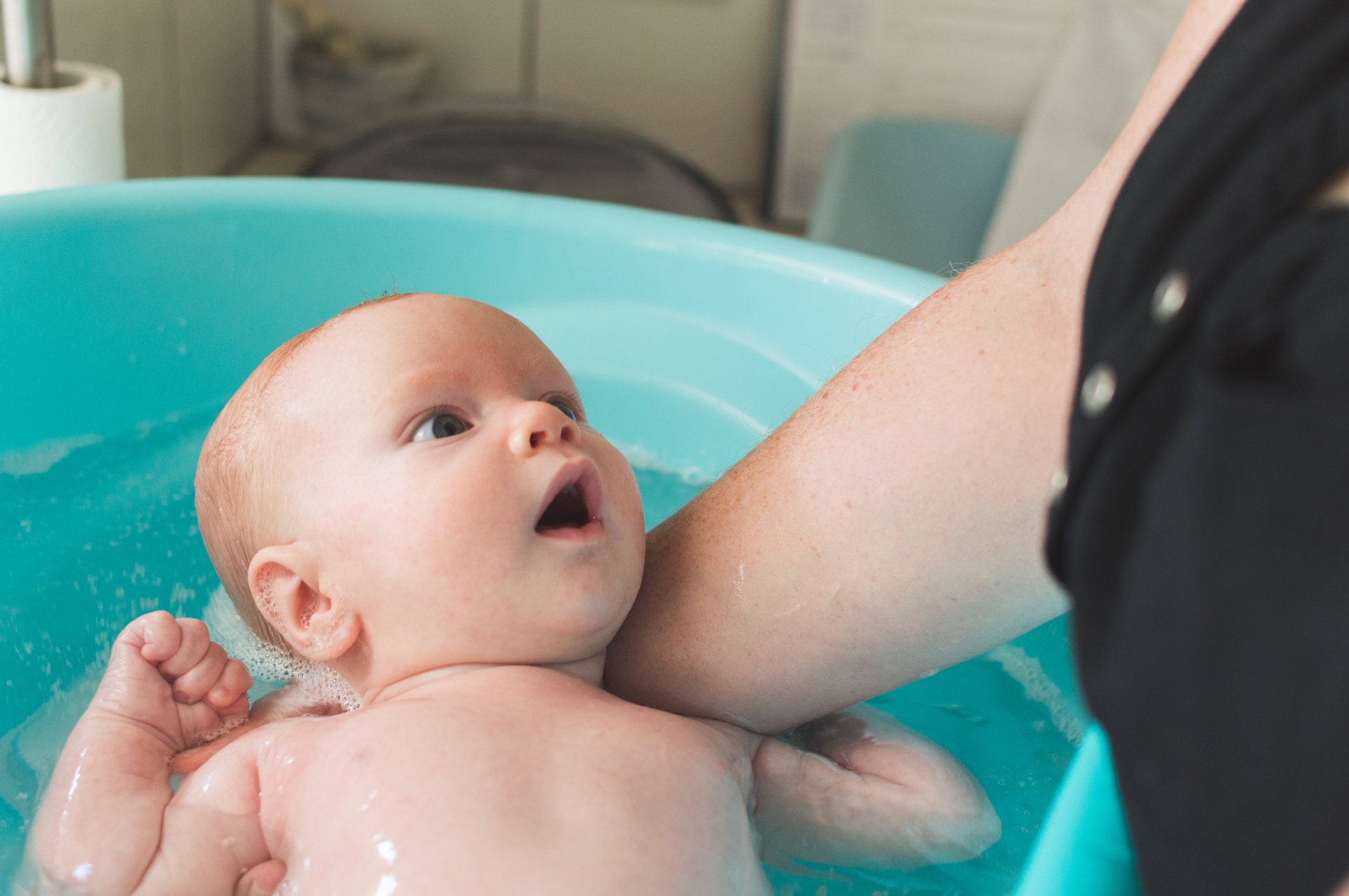 A 2-month old baby boy having a bath
